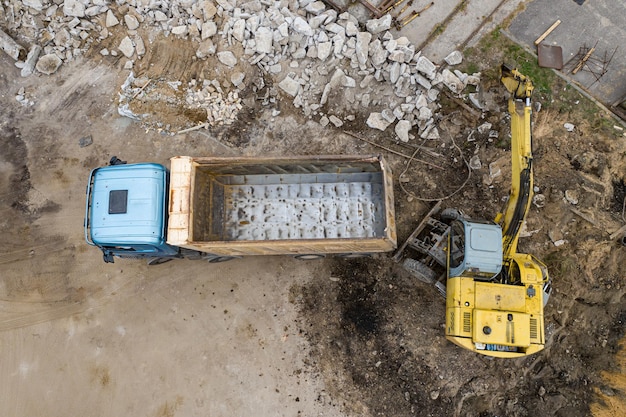 Excavator loads sand in a truck top view