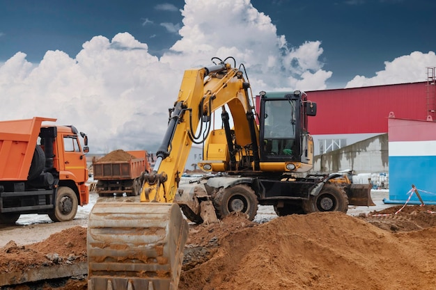 An excavator loads soil or sand into a dump truck Pit development Earthworks with the help of heavy construction equipment