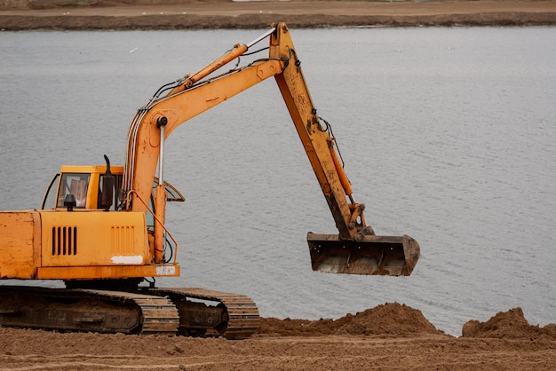 Excavator machine doing an earthwork on a shore