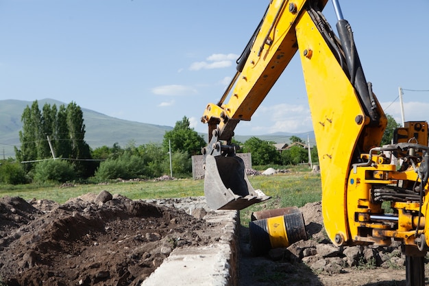 Excavator and new building in the field