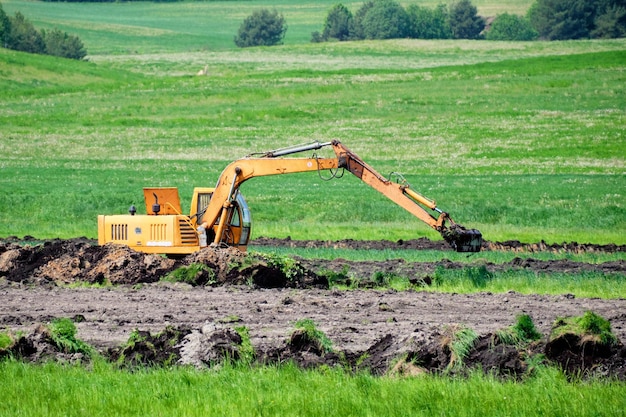 Photo excavator operation on a green field