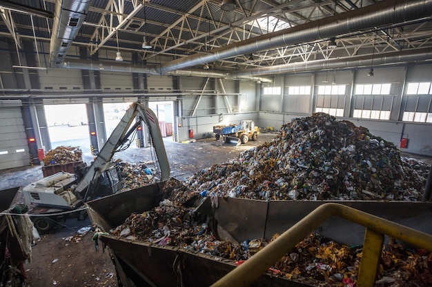 Excavator on primary sorting of garbage at waste processing\
plant separate garbage collection recycling and storage of waste\
for further disposal business for sorting and processing of\
waste