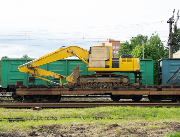 掘削機、トラクター付きの特別修理列車。かさばる機器の輸送