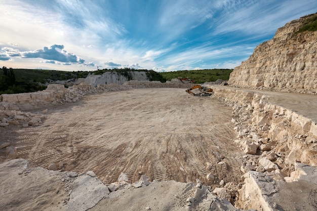 Excavator stands on the background of a stone quarry.