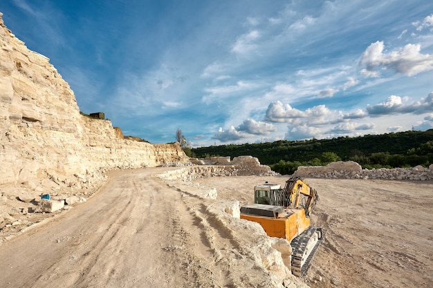 Excavator stands on the background of a stone quarry.