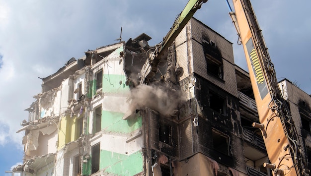 Foto escavatore con frantoio idraulico alla demolizione di un edificio residenziale ristrutturazione della città