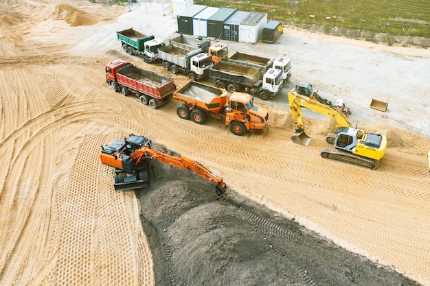 Escavatori e altre attrezzature da costruzione che lavorano in un cantiere, vista dall'alto