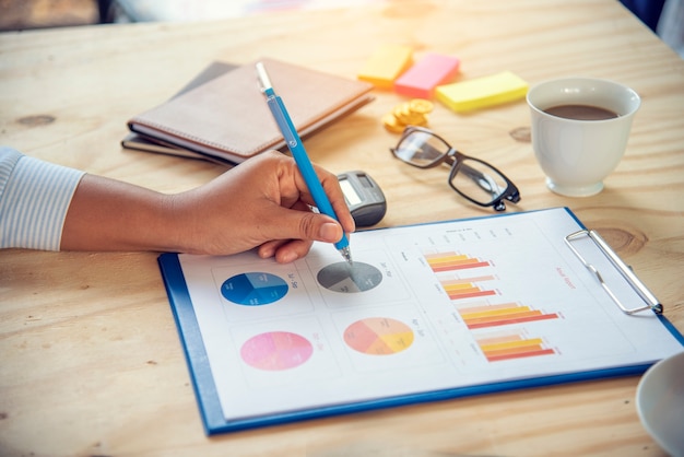 Foto statistica del grafico di analisi dei dati aziendali del foglio di calcolo delle statistiche di excel con il numero di dati del grafico e della tabella nel database dei grafici. le mani del ragioniere che indicano i grafici del grafico di affari del documento del foglio di calcolo finanziario di excel stat