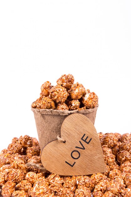 Excellent caramel popcorn in paper cup and wooden heart