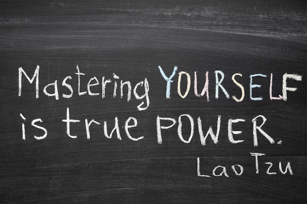 Excerpt from famous Lao Tzu quote "Mastering others is strength. Mastering yourself is true power." handwritten on blackboard