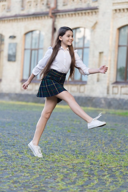 Excited about holidays. Happy child celebrate holidays outdoors. Energetic girl marching in school uniform. School holidays. Summer holidays or vacation. Leisure and free time.