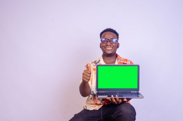 Excited african american man in casual black tshirt isolated on white background People lifestyle concept Mock up copy space Hold laptop pc computer with blank empty screen