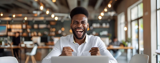흥분 된 아프리카계 미국인 남자가 사무실에서 노트북으로 일하면서 성공을 축하합니다 성공의 축하 개념 아프리카계 미국인이 사무실 환경 노트북 작업 흥분