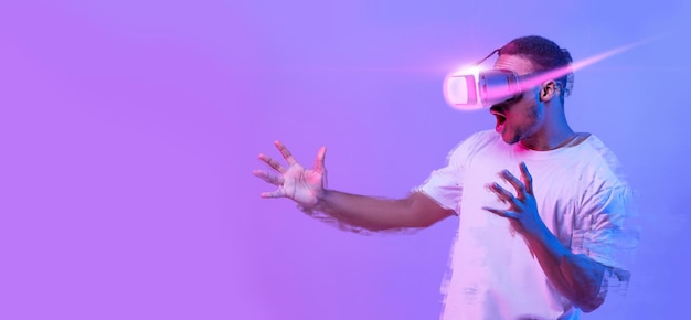 Возбужденный афроамериканец играет в видеоигры в очках виртуальной реальности