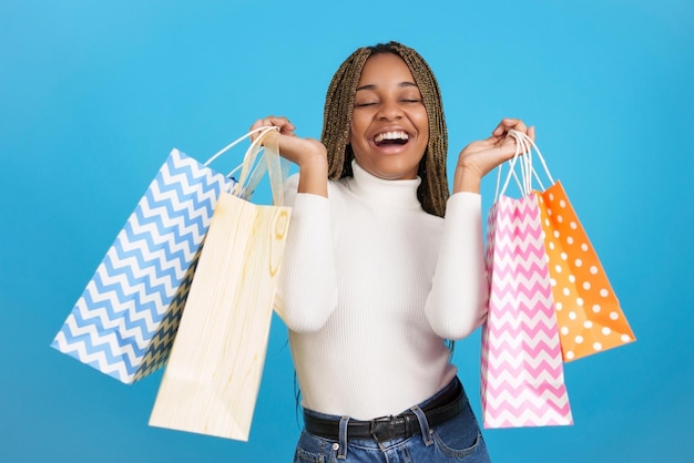 Excited african woman with many shopping bags