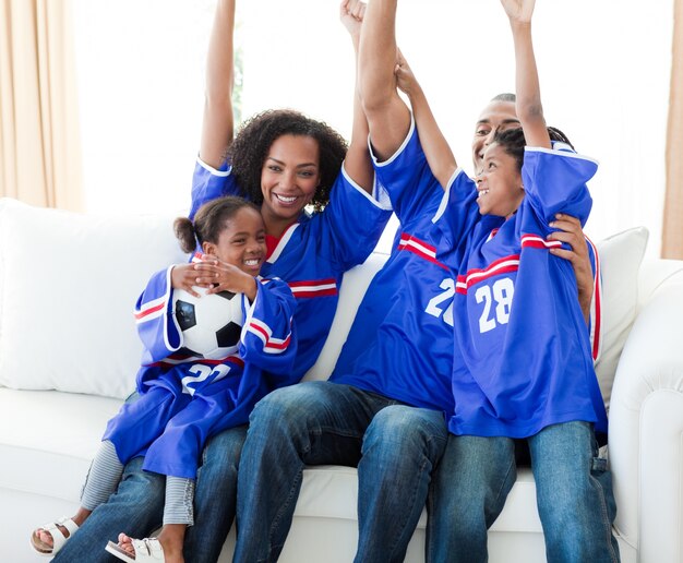 Excited Afro-American family celebrating a football goal