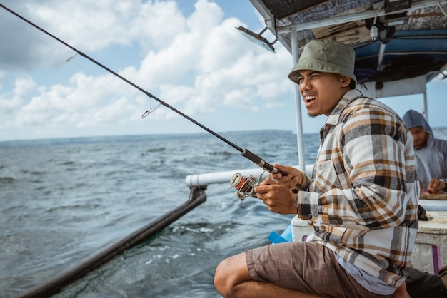 Excited angler reels in fishing line while casting