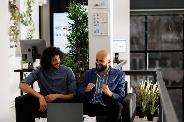 Photo excited arab managers celebrating sales increase while checking report