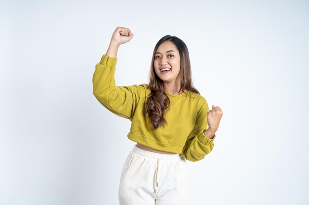 Excited asian woman clenching hands while celebrating success