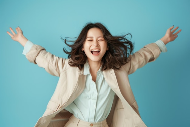 Excited asian woman jumps and smiles on blue background