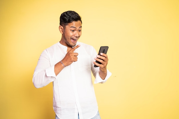 Excited asian young man surprised when looking at the screen