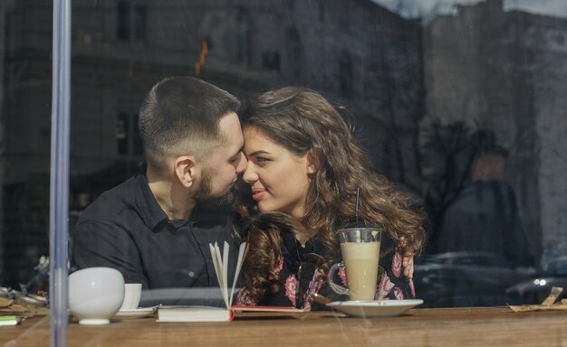 Excited to be together. Lovely young couple sit at the street caffee