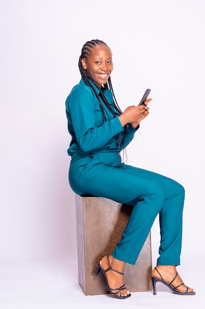 Eccitata ragazza d'affari africana nera mentre legge uno smartphone seduto a leggere notizie online, fare shopping