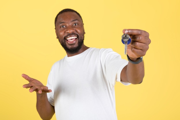 Excited Black Guy Showing Keys Buying House Over Yellow Background