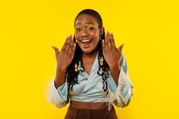 Excited Black Lady Shouting In Excitement On Yellow Studio Background