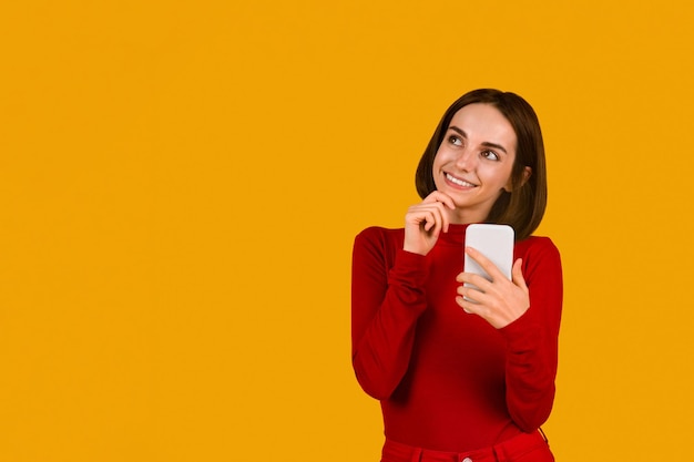 Excited brunette woman checking newest mobile app using phone