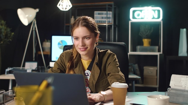 Excited business woman enjoying important information in dark coworking