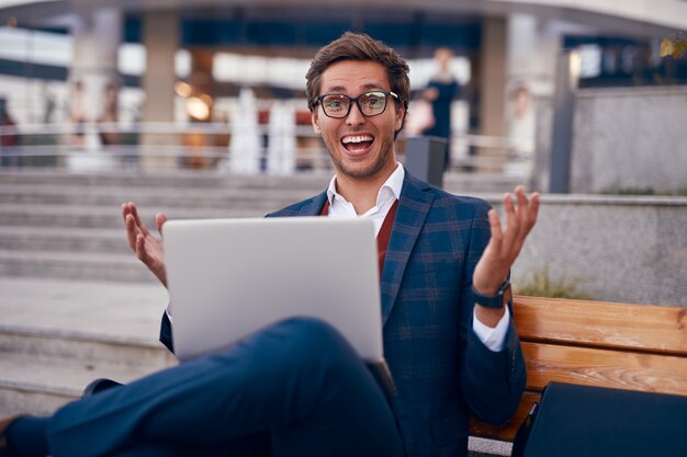 Excited businessman with laptop celebrating success