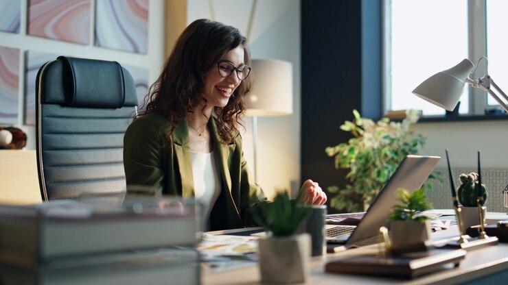 Photo excited businesswoman talking video call sitting desk modern office close up
