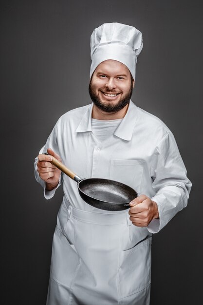 空のフライパンを見せて興奮している料理人