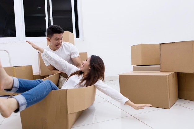 Excited couple playing with a cardboard box