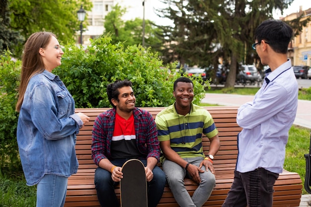 Excited diverse friends sitting on wooden bench