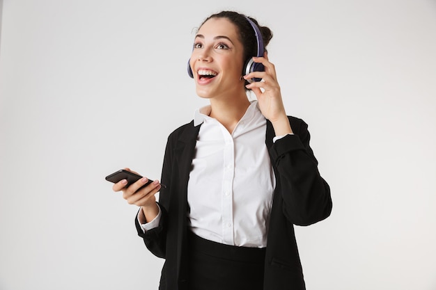 Excited emotional young business woman listening music