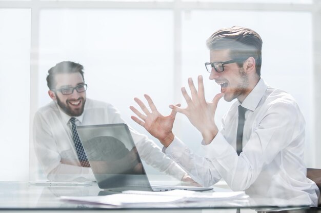 Excited employees enjoying the good news on the Internetthe concept of victory