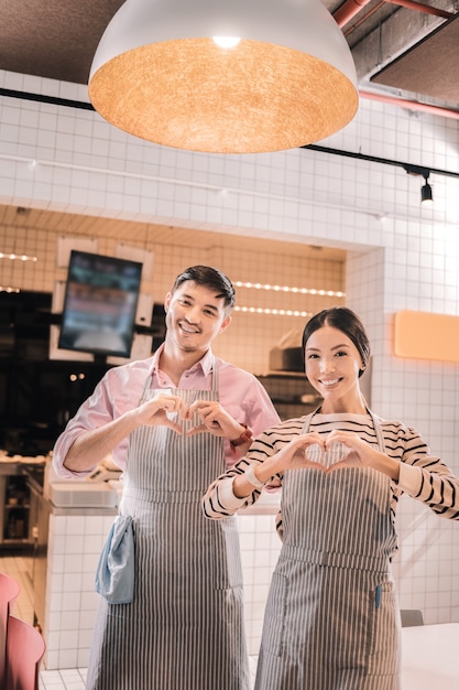 Imprenditori entusiasti. coppia di giovani imprenditori di bell'aspetto che si sentono eccitati all'apertura della loro sala caffè