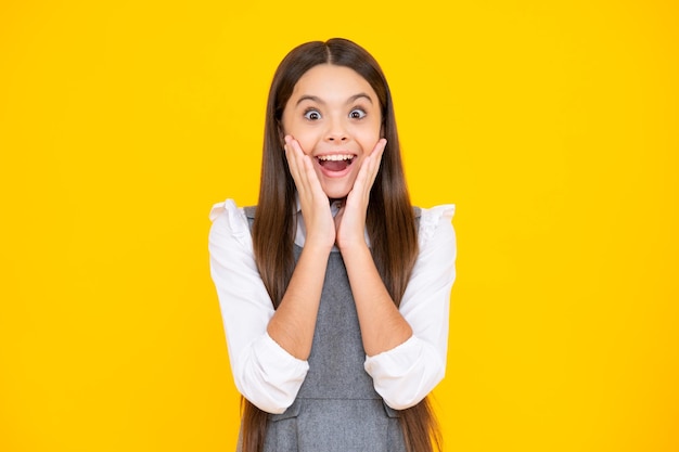 Excited face Amazed expression cheerful and glad Emotional portrait of caucasian teenager child girl isolated on studio yellow background