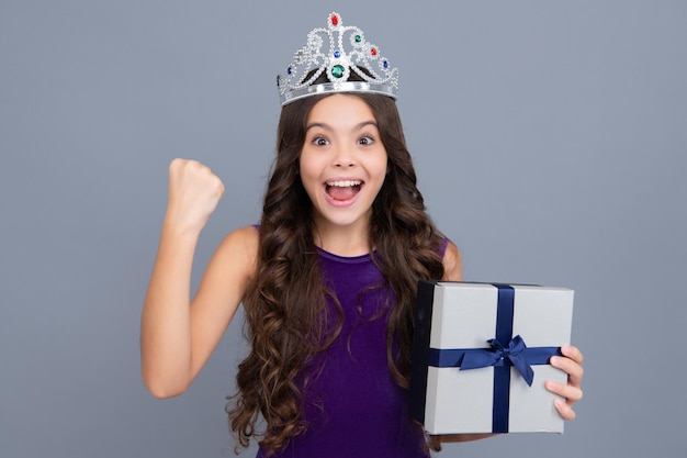 Excited face cheerful emotions of teenager girl Child teen girl 1214 years old with gift on grey