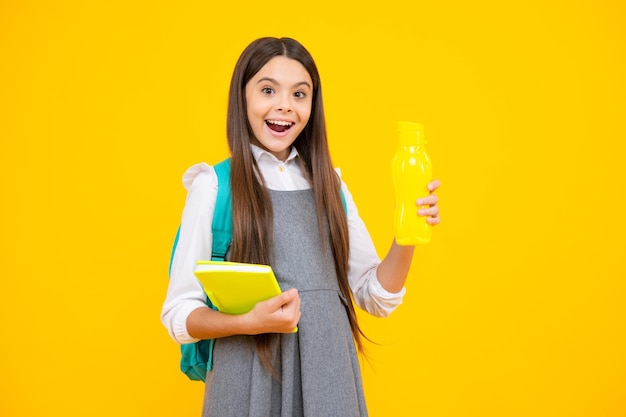 Excited face Cute school girl with backpack holding water bottle Amazed expression cheerful and glad