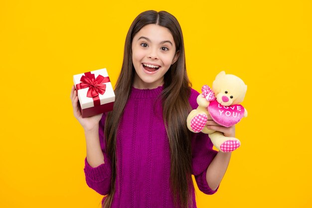 Excited face Cute teenager child girl congratulate with valentines day giving romantic gift box Present greeting and gifting concept Birthday holiday concept Amazed expression