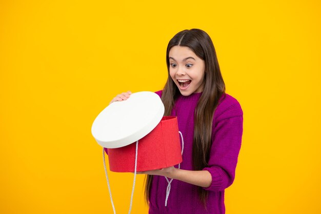 Excited face emotional teenager child hold gift on birthday funny kid girl holding gift boxes celebrating happy new year or christmas amazed expression cheerful and glad