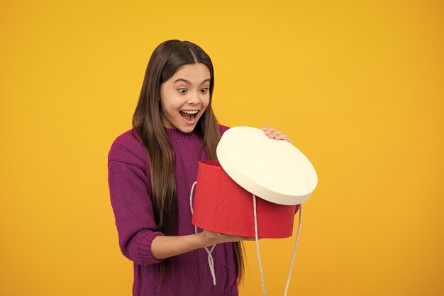 Excited face Emotional teenager child hold gift on birthday Funny kid girl holding gift boxes celebrating happy New Year or Christmas Amazed expression cheerful and glad