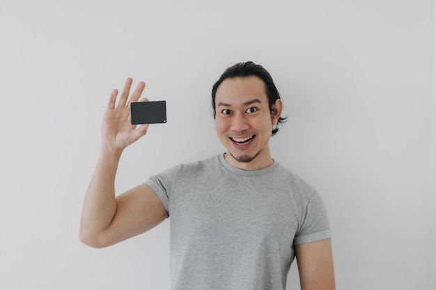 Excited face of man showing black mockup card in his hand