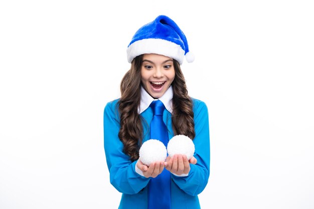 Excited face Portrait a smiling teen girl with blue santa hat shirt and necktie hold snow ball bauble isolated on white background Merry Christmas sale New Year celebration concept