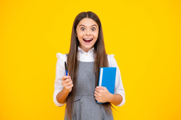 Excited face school child with book learning and education\
amazed expression cheerful and glad