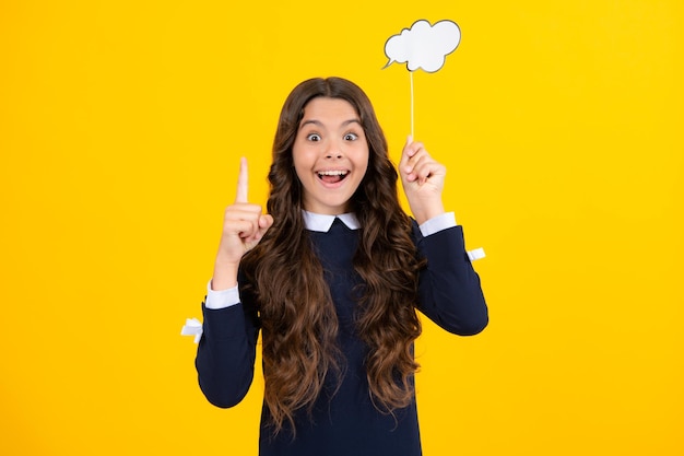 Excited face teen girl holding clouds empty space thinking bubble comment cloud over yellow