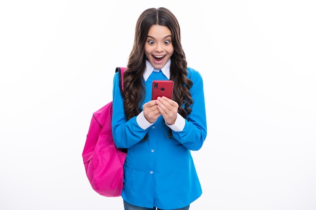 Excited face Teen student girl hold backpack use mobile cell phone on white background Education